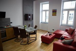 AM-Residence No 12 في فيينا: غرفة معيشة مع طاولة وأريكة حمراء
