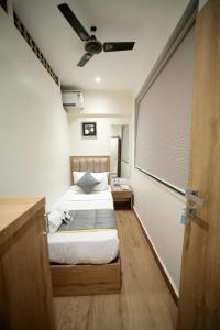 - une chambre avec un lit et un ventilateur de plafond dans l'établissement CABINSTAY-AIRPORT, à Mumbai