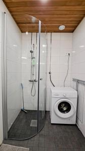 タンペレにあるKotimaailma Apartments - Parvekkeellinen keskustakaksio - Aleksanterinkatuのシャワー付きのバスルームにある洗濯機