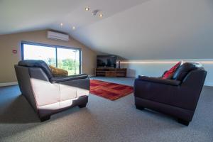 a living room with two chairs and a television at Dunston Stables- Spectacular Countryside Setting in Newton Abbot