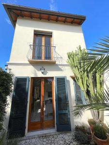Casa blanca con puertas de madera y balcón en Villa Giardino, en Forte dei Marmi