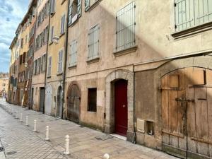 an old building with a red door on a street at L'escapade Toulonnaise in Toulon