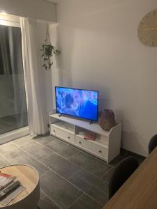 salon z telewizorem z płaskim ekranem na białej szafce w obiekcie Eau Bleue d'Eden w mieście Saint-Hilaire-de-Riez