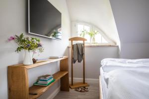 a bedroom with a bed and a tv on a wall at Ferienhaus Seeadler 9 in Fuhlendorf