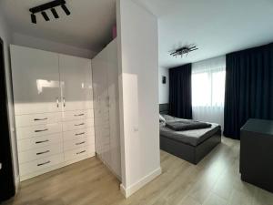 um quarto com armários brancos e uma cama nele em Apartament Panoramic View I Refugiu la înălțime em Bucareste