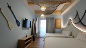 Habitación de hotel con 2 camas y TV en Mi Hai B&B, en Magong