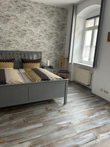 a bedroom with two beds and a brick wall at Ferienwohnung am Theaterplatz in Meißen
