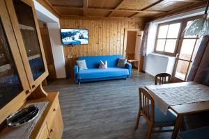 een woonkamer met een blauwe bank en een tafel bij Rohrmoser Appartements in Sankt Johann im Pongau
