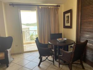 a dining room with a table and chairs and a window at Costa Bonita Apt in Culebra