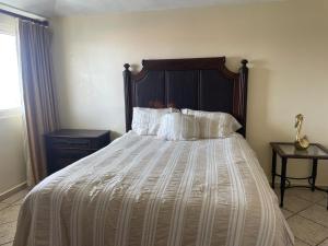 a bedroom with a bed with a wooden headboard and pillows at Costa Bonita Apt in Culebra