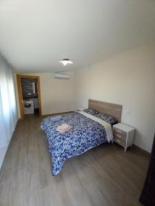 a bedroom with a bed with a blue comforter at Los Pinos Munera in Munera