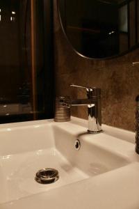 a bathroom sink with a faucet and a mirror at Eden Villa in Braşov