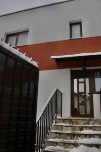 una casa con nieve en las escaleras y una puerta en Eden Villa, en Brasov