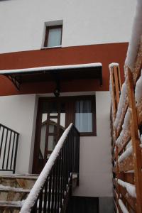 a house with snow on the railing and stairs at Eden Villa in Braşov