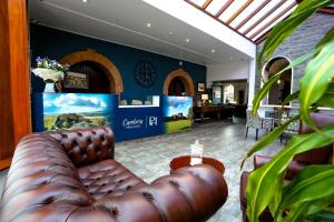 a brown leather couch in a room with a clock at Cumbria Park Hotel in Carlisle