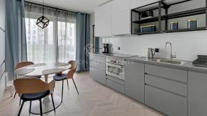 a kitchen with a table and chairs and a dining room at Lion Apartments - Angielska Grobla City Center&Parking in Gdańsk