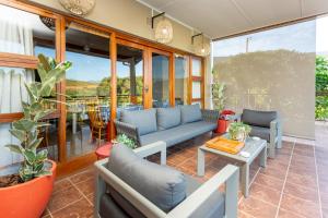 un patio con sofás azules y una mesa en Die Fonteine Country Guest House, en Oudtshoorn