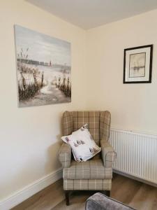 una sala de estar con una silla y una foto en la pared en Driftwood, en Eyemouth
