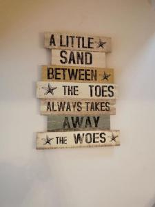 a sign that says a little sand between the toes always takes away the woes at Driftwood in Eyemouth