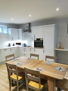 a kitchen with a wooden table and chairs at Driftwood in Eyemouth