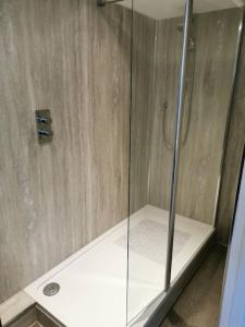 a shower with a glass door in a bathroom at Driftwood in Eyemouth
