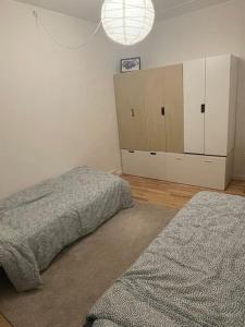 a bedroom with two beds and a white wall at Modern apartment in Ørestad in Copenhagen