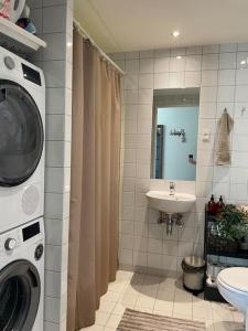 a bathroom with a washing machine and a sink at Modern apartment in Ørestad in Copenhagen