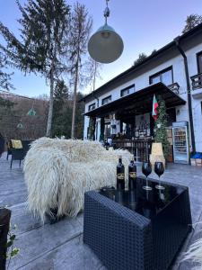 a table with wine glasses and a large haystack at Starite Borove in Sinagovtsi