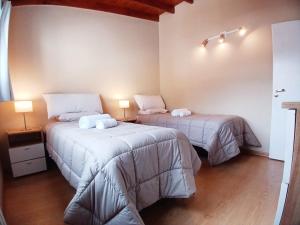 two beds in a room with two lamps at Aparts Merkaba in El Chalten