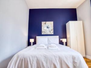 - une chambre avec un lit blanc et un mur bleu dans l'établissement Pass the Keys Central Apartment with king bed, à Lincoln