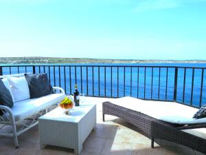 a balcony with a view of the water at Seafront apartment Terrace, lounger & Panoramic ocean views in Mellieħa