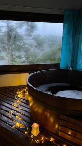 a large bath tub sitting in a window with lights at Rodeio das Lagoas in Cambará