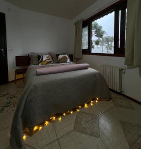 Rodeio das Lagoas في كامبارا: غرفة نوم بها سرير مع أضواء عليه