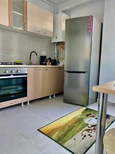 uma cozinha com um grande frigorífico de aço inoxidável em Garsonieră Trivale City em Piteşti
