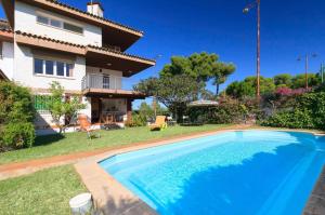 a villa with a swimming pool in front of a house at Villa Serena Planet Costa Dorada in Salou