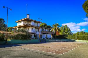 a building with a tennis court in front of it at Villa Serena Planet Costa Dorada in Salou