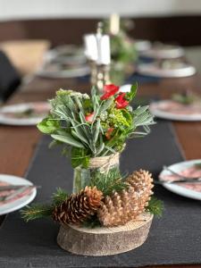 a vase with flowers and pine cones on a table at Starite Borove in Sinagovtsi