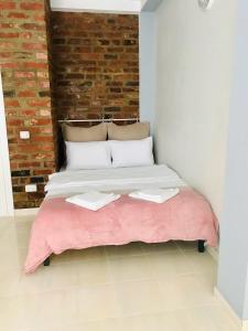a bed in a room with a brick wall at Vespasian 25 in Bucharest