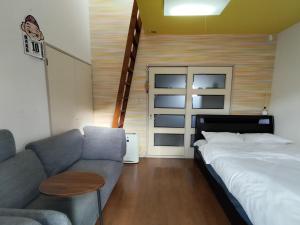 Meinohama的住宿－avanti house姪浜，客厅配有沙发和1张床