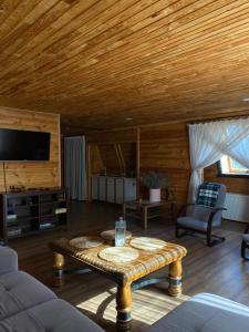 a living room with a wooden ceiling and a table at California in Khorodelets