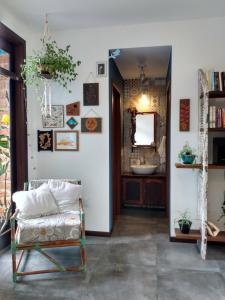 a room with a chair and a bathroom with a sink at Pousada Vila Guyrá in Florianópolis