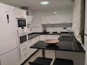 a kitchen with white appliances and a bowl on a table at Luxury centro Silgar in Sanxenxo