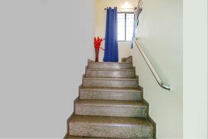 Una escalera con un jarrón de flores rojas. en FabExpress Osca Inn, en Nagpur