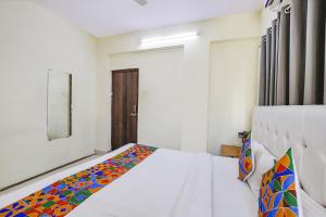 a bedroom with a bed and a mirror in it at FabExpress Osca Inn in Nagpur