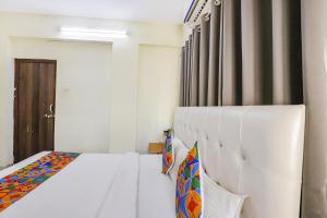 1 dormitorio con cama blanca y ventana en FabExpress Osca Inn, en Nagpur