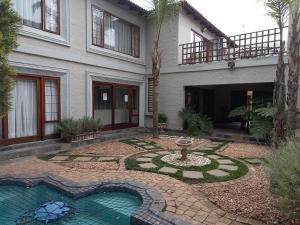 a house with a fountain in the middle of a yard at Troas Boutique hotel in Vanderbijlpark