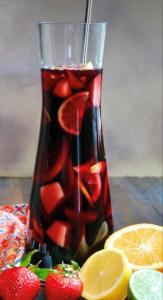 a drink in a vase with strawberries and oranges at Hostel Zrće All Inclusive- ALL YOU CAN DRINK AND EAT! in Novalja