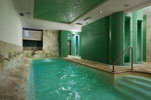 a pool in a room with green walls at Hotel Recostano Residence in Trevignano Romano