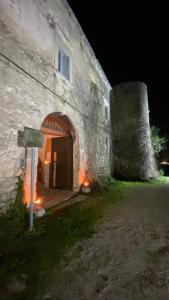 an old stone building with a door and a tower at Barone Gambadoro in Monte SantʼAngelo