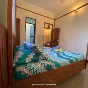 a bedroom with a bed with a large mirror at E&E Holiday Apartment in Dar es Salaam